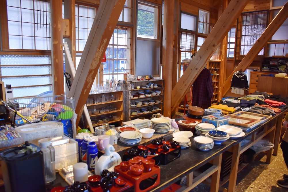 くるくるショップ店内。子ども服から、様々な種類のお皿やコップ、年季の入った雑貨やおもちゃなどが並ぶ