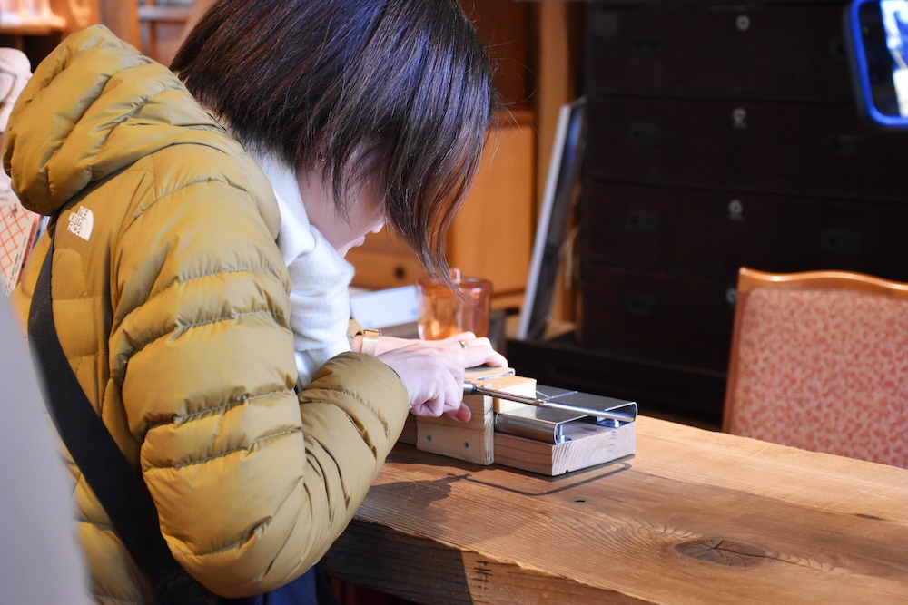 ホテルのチェックイン時に宿泊者が石鹸を専用の器具でカットしている様子