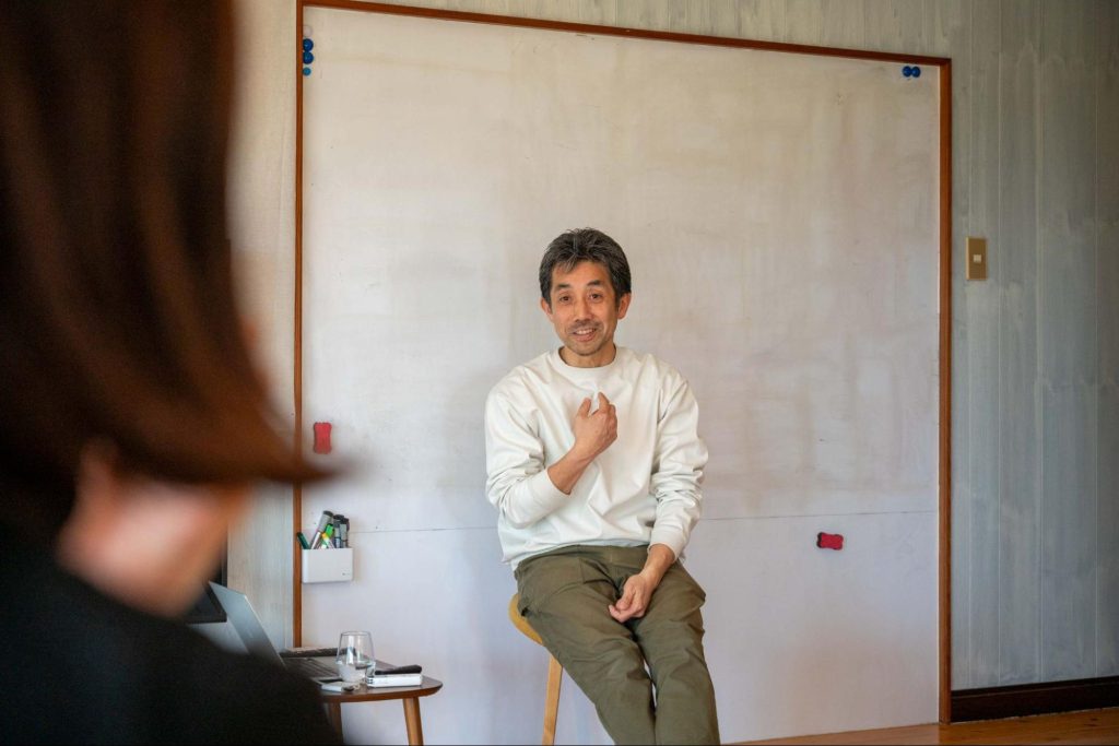 椅子に腰掛け話をする中川敬文さん