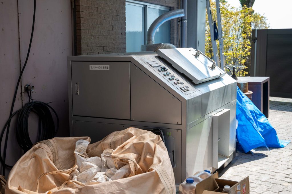 レストラン裏に設置された食べ残しや調理カスを堆肥化する高温乾燥発酵処理機械