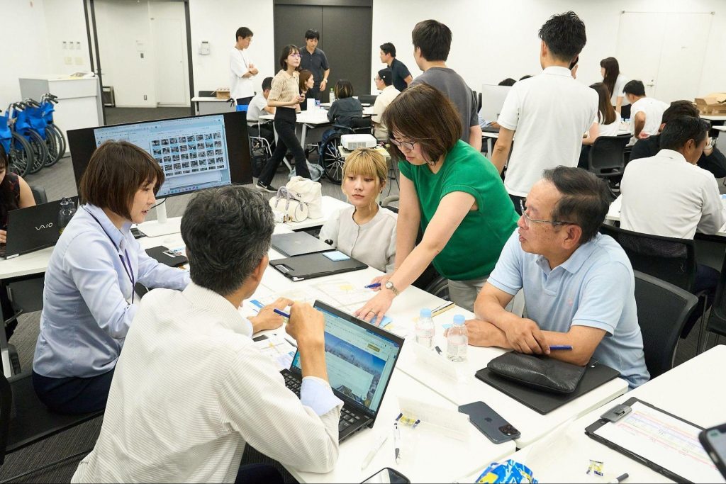 会議室でリードユーザーと社員が、ノートPCや資料を見ながらマップ案について議論している様子