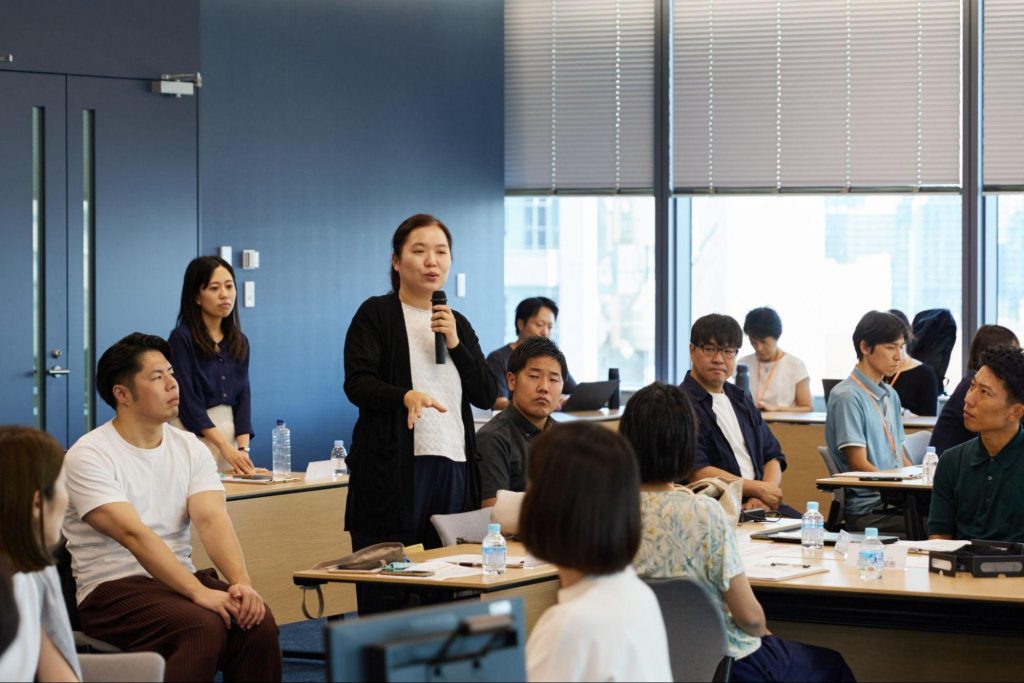 視覚障がい当事者として、マイクを持ってBFSのアクセシビリティについて話す野村不動産ソリューションズの小国さん