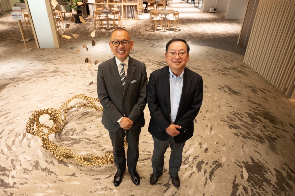 CEO Arai and Professor Maeno standing side by side, smiling at the camera.